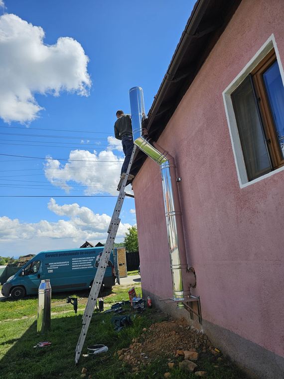 Coș de fum din inox montat pe peretele lateral al unei case