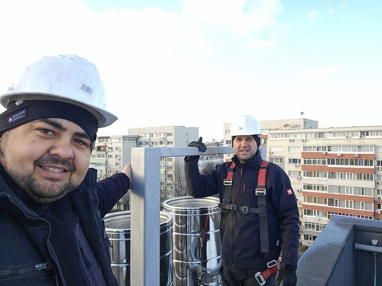 Echipa Servicii Coșerit, echipată cu căști de protecție, pe terasa unei clădiri